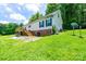 Rear view of house with a wooden deck, stairs, and a well-maintained lawn with a walkout basement at 3659 Vashti Rd, Taylorsville, NC 28681