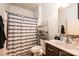 Well-lit bathroom featuring a vanity with dark wood cabinets and a shower with a striped curtain at 3659 Vashti Rd, Taylorsville, NC 28681
