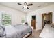 A bright bedroom with a ceiling fan, two windows, an open door and a small television at 3659 Vashti Rd, Taylorsville, NC 28681