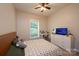 A bright bedroom featuring a bed with a patterned cover, a window, and dresser with a television at 3659 Vashti Rd, Taylorsville, NC 28681