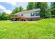 This home features a sturdy brick foundation and a charming wooden deck overlooking the expansive yard at 3659 Vashti Rd, Taylorsville, NC 28681
