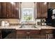 Close-up of a kitchen sink area featuring wood cabinets, granite countertops, and a window with a peaceful view at 3659 Vashti Rd, Taylorsville, NC 28681