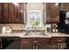 Kitchen with granite countertops, black appliances, stainless steel sink, and dark wood cabinetry at 3659 Vashti Rd, Taylorsville, NC 28681