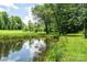 Scenic pond surrounded by mature trees and greenery, creating a tranquil outdoor setting at 3659 Vashti Rd, Taylorsville, NC 28681