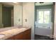 Bathroom featuring double vanity, granite countertops, large mirror, and soaking tub at 3664 Gaston Day School Rd, Gastonia, NC 28056