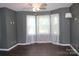 Bedroom with modern ceiling fan, hardwood floors, and three light-filled windows at 3664 Gaston Day School Rd, Gastonia, NC 28056