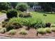 Well-maintained front yard featuring a lush garden bed with colorful flowers and manicured greenery at 3664 Gaston Day School Rd, Gastonia, NC 28056