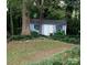 Backyard shed with siding and a dark roof surrounded by mature trees and attractive landscaping at 3664 Gaston Day School Rd, Gastonia, NC 28056