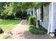 Brick walkway lined with lush greenery leading to a charming home, creating a welcoming entrance at 3664 Gaston Day School Rd, Gastonia, NC 28056