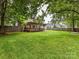 Spacious backyard with a deck, patio, mature trees, and a privacy fence at 3905 Brittany Ct, Indian Trail, NC 28079