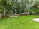 Landscaped backyard with green grass, a wooden fence, and a gravel fire pit area at 3905 Brittany Ct, Indian Trail, NC 28079