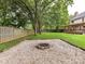Well-maintained backyard featuring a gravel fire pit, wooden fence, and lush green lawn at 3905 Brittany Ct, Indian Trail, NC 28079