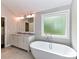 Spacious bathroom featuring double vanity and soaking tub by the window at 3905 Brittany Ct, Indian Trail, NC 28079
