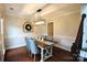 Dining area with wood floors and table with four chairs beneath a modern light fixture at 3905 Brittany Ct, Indian Trail, NC 28079