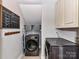 Functional laundry room featuring modern machines, overhead storage, and a convenient calendar at 3905 Brittany Ct, Indian Trail, NC 28079