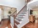 Traditional staircase with a wooden handrail and access to the dining room at 3905 Brittany Ct, Indian Trail, NC 28079