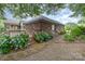 Landscaped backyard with brick pathway and vibrant flowers at 43 Paddington Sw Dr, Concord, NC 28025
