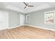 A spacious bedroom with light green walls, wood floor, a ceiling fan and many windows at 43 Paddington Sw Dr, Concord, NC 28025