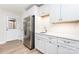 Bright kitchen features stainless steel appliances, modern white cabinetry, light countertops, and wood flooring for convenience at 43 Paddington Sw Dr, Concord, NC 28025