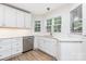 Bright and functional kitchen featuring modern stainless steel appliances, white cabinets, light countertops, and wood floors at 43 Paddington Sw Dr, Concord, NC 28025