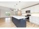 Well-lit kitchen featuring a large island, stainless steel appliances, modern cabinets, and wood floors for cooking at 43 Paddington Sw Dr, Concord, NC 28025