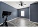 Modern bedroom featuring blue walls, wood-look floors, and a ceiling fan at 4420 Bright Rd, Charlotte, NC 28214