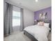 Bedroom with large window, drapes, and a lilac accent wall at 4420 Bright Rd, Charlotte, NC 28214