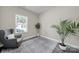 Bright living room featuring a comfortable gray armchair, neutral walls, and wood-look flooring at 4420 Bright Rd, Charlotte, NC 28214
