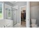 Elegant bathroom featuring a glass-enclosed shower, soaking tub, and access to a closet at 4605 Sarandon Ct, Charlotte, NC 28215