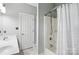Bathroom with a shower-tub combo, white shower curtain, single sink vanity, and white door at 4605 Sarandon Ct, Charlotte, NC 28215