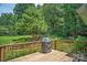 Elevated view from the wooden deck showcasing a serene and private tree-filled backyard, great for relaxing or grilling at 4605 Sarandon Ct, Charlotte, NC 28215