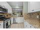Bright kitchen featuring stainless steel appliances, granite countertops, white cabinets, and tile flooring at 4854 S Hill View Dr, Charlotte, NC 28210