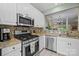Modern kitchen features stainless steel appliances, granite countertops, white cabinets, and open view to living spaces at 4854 S Hill View Dr, Charlotte, NC 28210