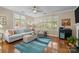 Bright living room with a blue rug, many windows with blinds, a white sofa, and hardwood floors at 4854 S Hill View Dr, Charlotte, NC 28210