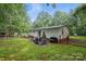 Wide backyard featuring a patio area with outdoor seating, mature trees, and ample green space at 4921 Sierra Dr, Maiden, NC 28650