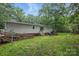 Open backyard featuring a patio area, a ramp and mature trees, offering privacy and space for outdoor activities at 4921 Sierra Dr, Maiden, NC 28650