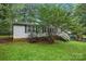 Side view of a home with a well-maintained front yard, mature trees, light gray siding, and a black fenced yard at 4921 Sierra Dr, Maiden, NC 28650