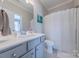 Neutral bathroom features a gray vanity with a white sink and a white shower curtain at 5256 Meadowcroft Way, Fort Mill, SC 29708