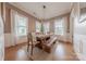 Dining room with wooden table and bench seating, illuminated by a modern chandelier at 5256 Meadowcroft Way, Fort Mill, SC 29708