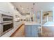Bright kitchen with stainless appliances, marble countertops, and pendant lighting over a gray island at 5256 Meadowcroft Way, Fort Mill, SC 29708