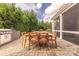 Charming outdoor dining area with wooden table, stone patio, lush greenery, and built in gas grill at 5256 Meadowcroft Way, Fort Mill, SC 29708