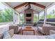 Relaxing sunroom featuring a stone fireplace, vaulted ceiling, comfortable seating, and backyard views at 5256 Meadowcroft Way, Fort Mill, SC 29708