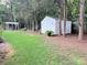 Spacious backyard featuring a storage shed, mature trees, and an inviting gazebo at 5434 Starflower Dr, Charlotte, NC 28215