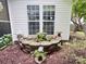Backyard with vinyl siding, two windows, and a rock planter with flowers at 5434 Starflower Dr, Charlotte, NC 28215
