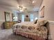 Comfortable bedroom features floral comforter, ceiling fan, and dresser with a mirror and bright natural light at 5434 Starflower Dr, Charlotte, NC 28215
