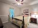 The bedroom features a floral comforter, a ceiling fan, and a bright window providing soft natural light at 5434 Starflower Dr, Charlotte, NC 28215