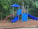 Community playground featuring a climbing wall and two slides, set in a wooded area at 5434 Starflower Dr, Charlotte, NC 28215