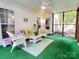 Charming screened porch with wicker furniture, green flooring, and ample space for relaxation at 5434 Starflower Dr, Charlotte, NC 28215