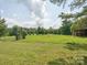 Expansive backyard featuring a large grassy area, trees, and a shed at 5632 Zion Church Rd, Concord, NC 28025