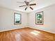 Bright bedroom featuring beautiful hardwood floors, two windows and a ceiling fan at 5632 Zion Church Rd, Concord, NC 28025